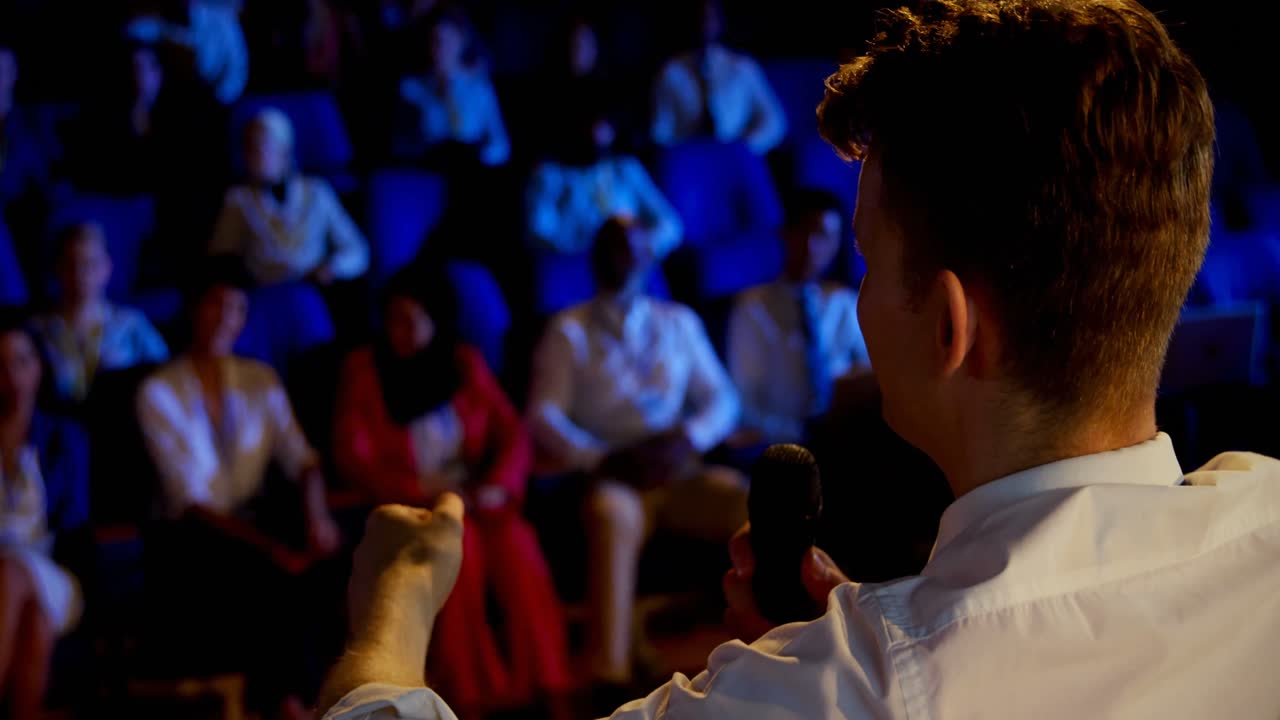 joven empresario caucásico hablando en un seminario de negocios en el auditorio 4k