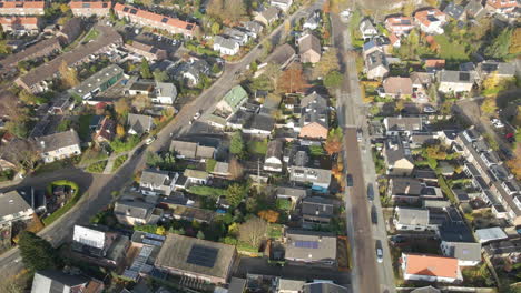 aerial of cars driving through a beautiful suburban neighborhood in autumn