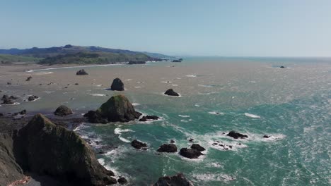 drone shot panning over the pacific northwest coastline on a sunny day