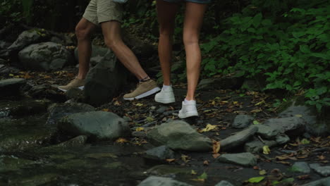 couple hiking through a forest stream