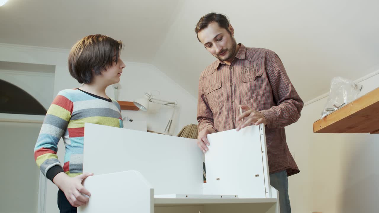 un padre enseña a su hijo a montar muebles. importancia de la transferencia de experiencia y capacitación. negocio familiar y ahorro del presupuesto familiar