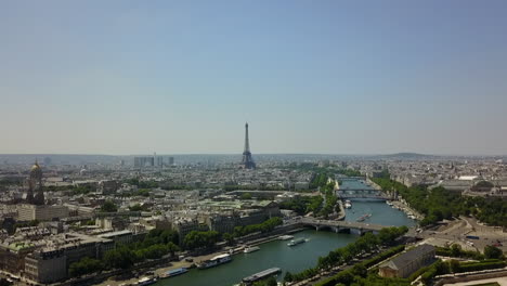 Aufsteigende-Luftaufnahmen-Des-Verkehrs-Auf-Und-Um-Die-Seine-In-Der-Stadt.-Hohe-Struktur-Des-Eiffelturms-In-Der-Ferne.-Paris,-Frankreich