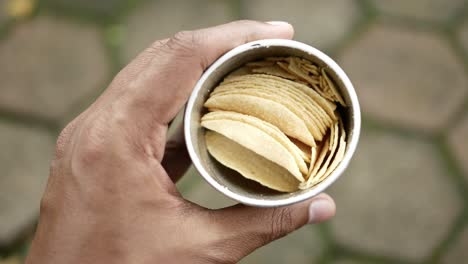 hombres sosteniendo un paquete abierto de papas fritas