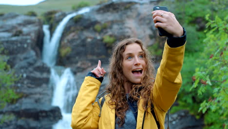 woman taking selfie by waterfall