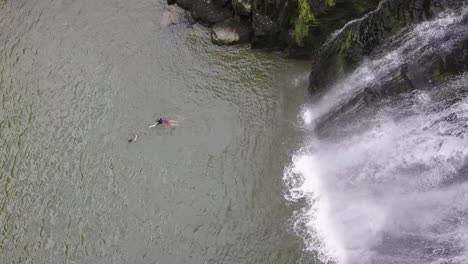 Ein-Klippenspringer-Landete-Neben-Einem-Wasserfall-Im-Wasser,-Ein-Freund-Gratuliert-Ihm