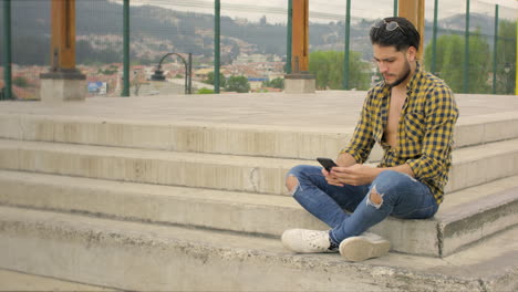 chico guapo usando teléfono celular en un parque