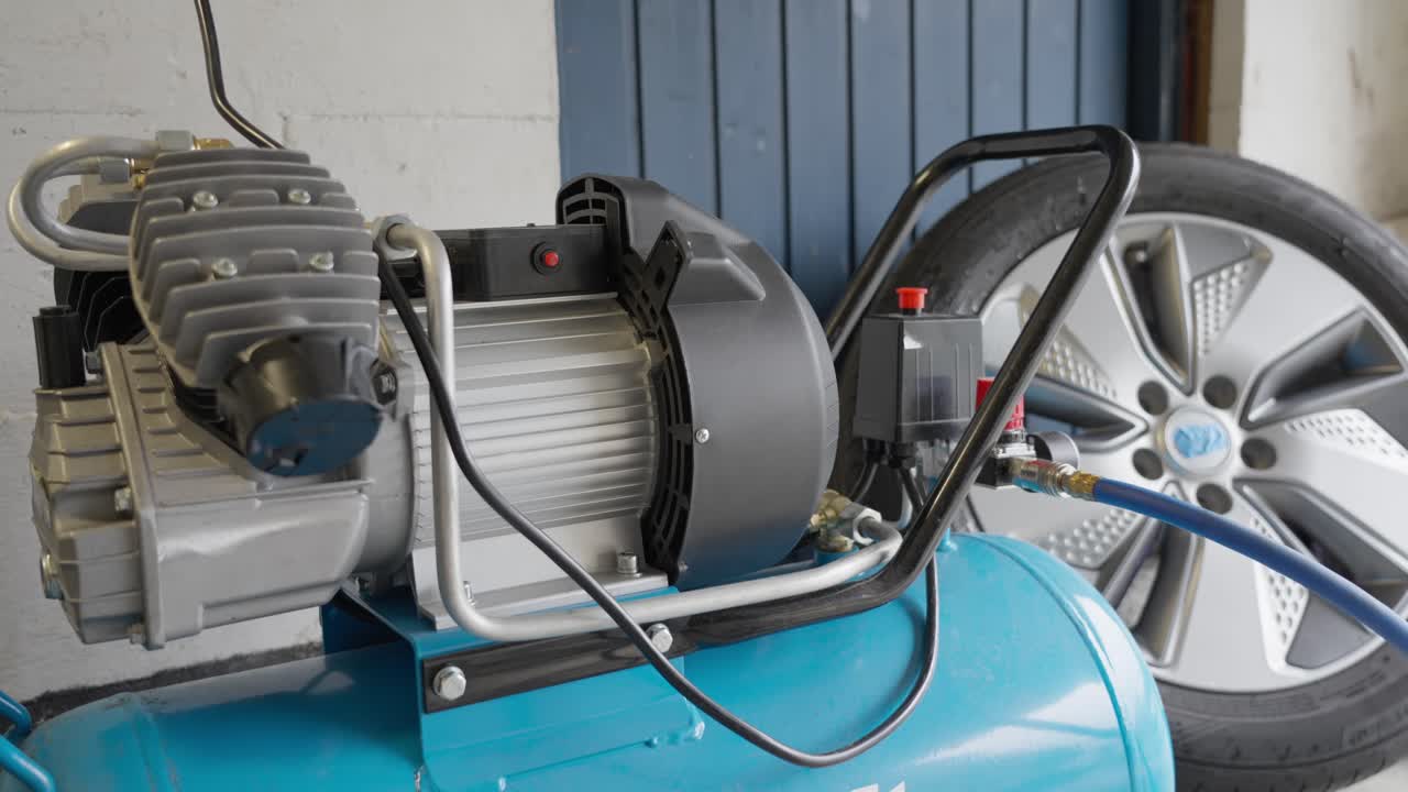 Person reaches down to turn on air compressor by pulling on red power button, close up