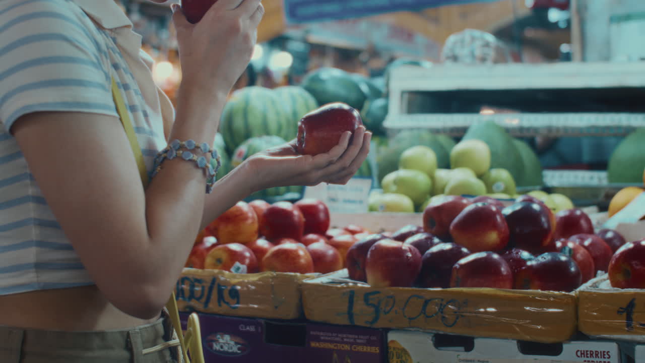 Asian Woman Buying Apples at Local Market