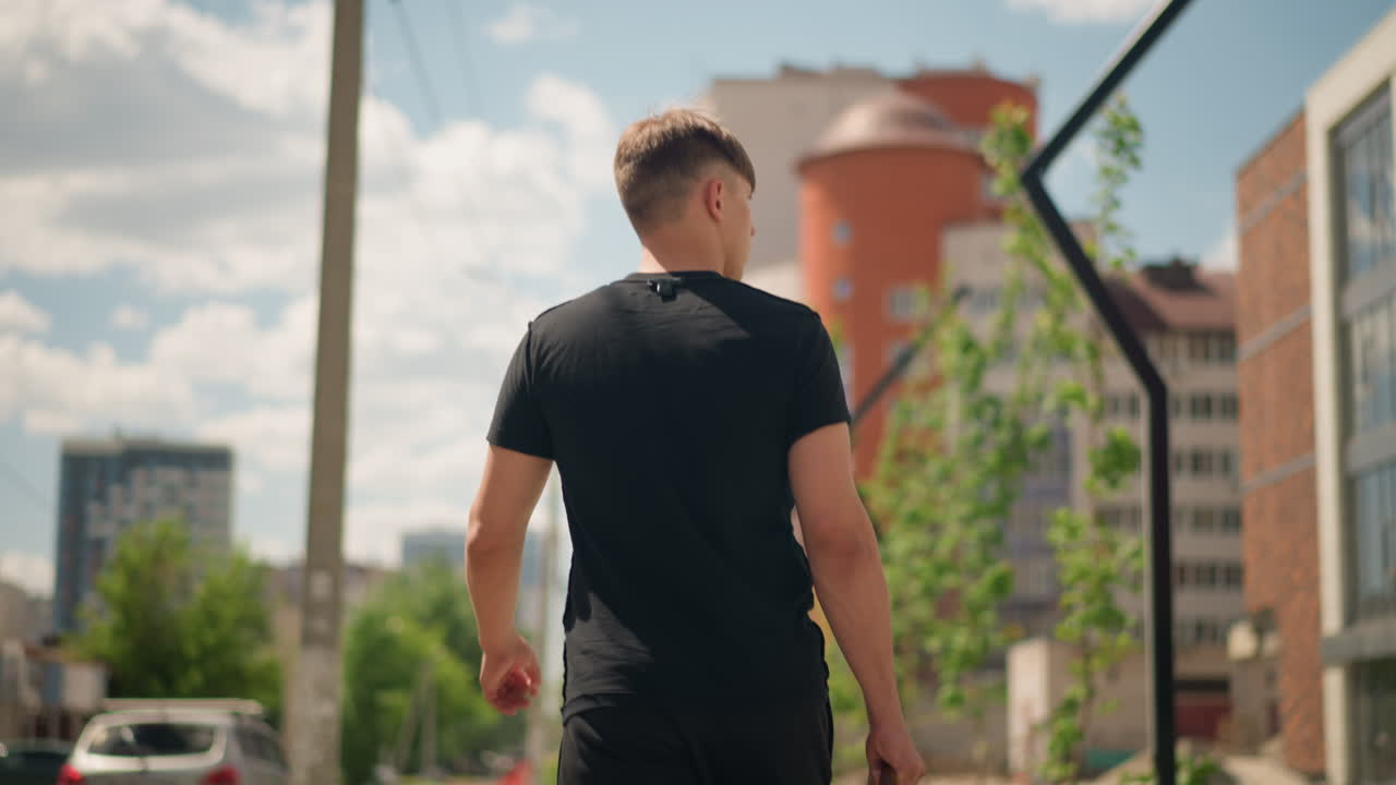 reflexión durante paseo urbano; joven contemplativo pasea por un entorno urbano ajetreado; joven solitario observa y reflexiona sobre el vibrante skyline urbano durante un paseo informal