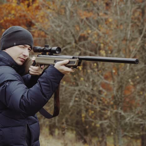 cazador con arma en el bosque