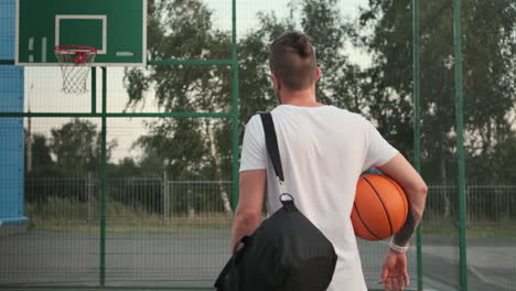 man with basketball backpack on outdoor court