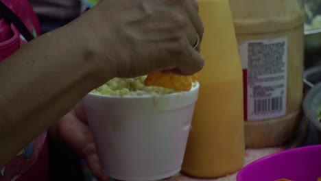 un vendedor de alimentos al azar está decorando comida callejera para sus clientes