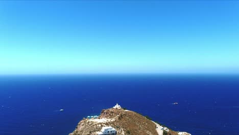 vista aérea 4k azul mar y cielo sobre el faro akrotiri en la ladera escénica en santorini grecia