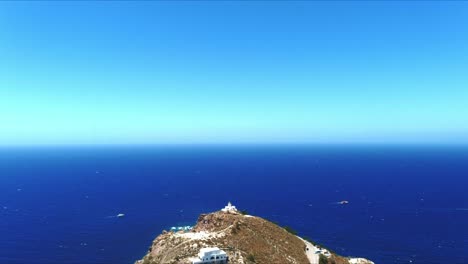 aerial 4k blue sea and sky top view over akrotiri lighthouse on scenic hillside in santorini greece