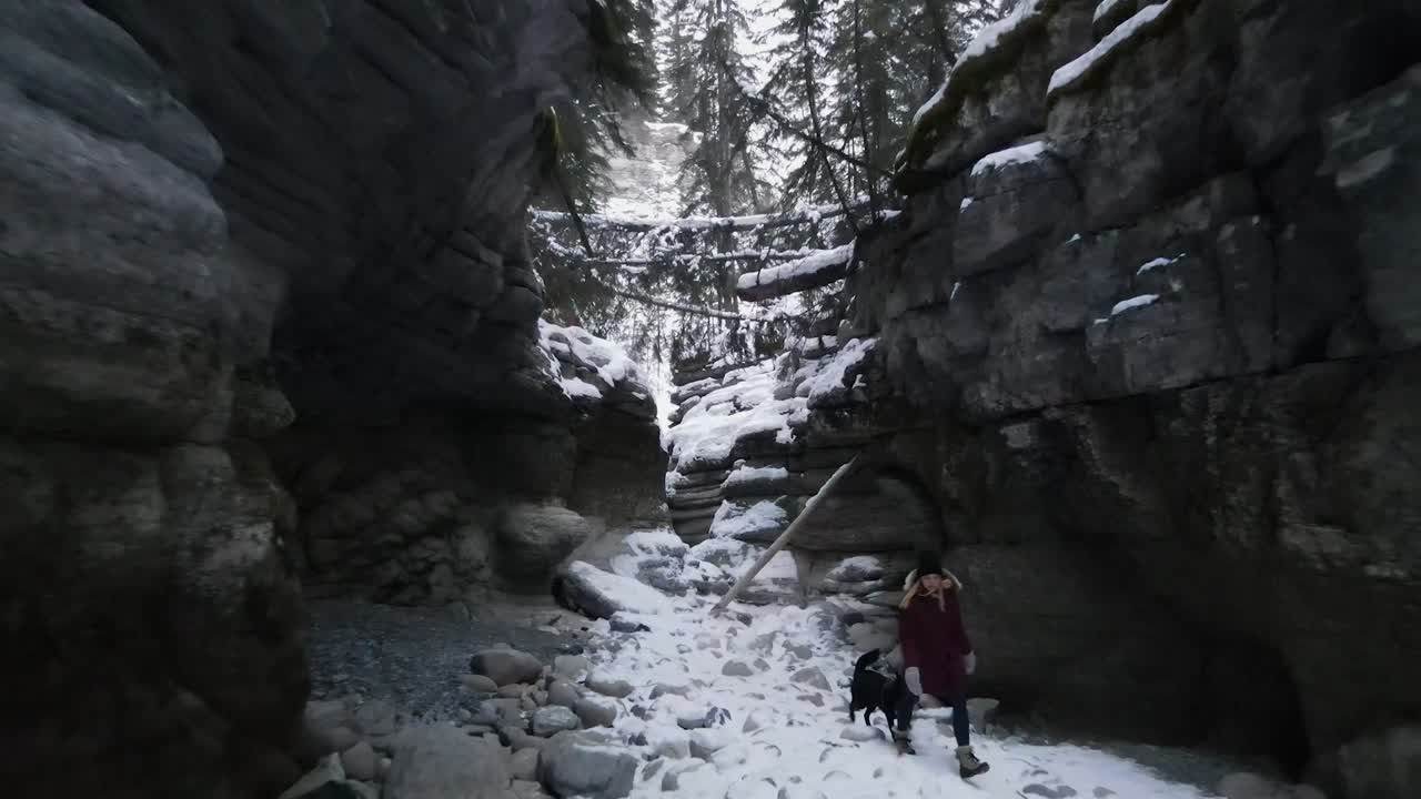 Girl and dog walking through Maligne Canyon