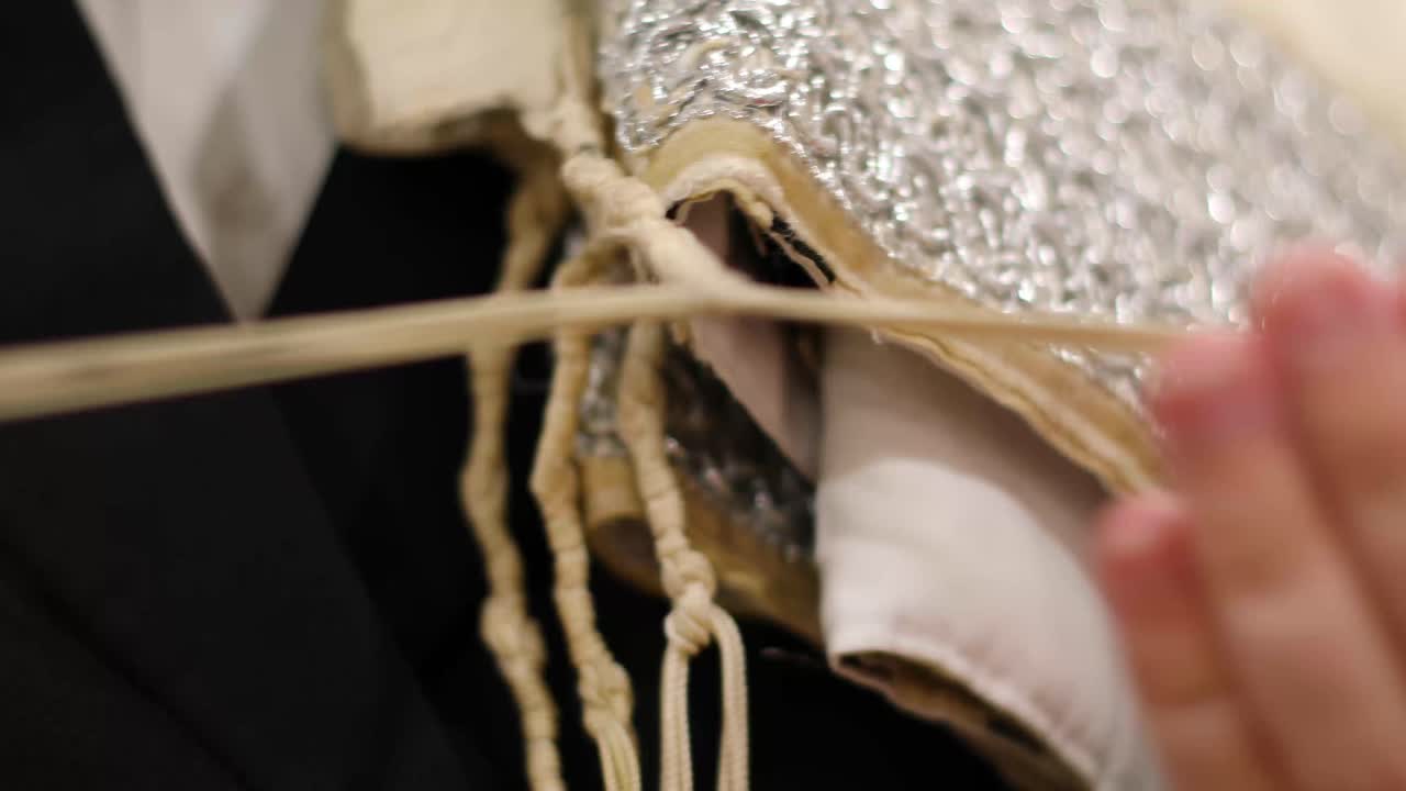 Jewish man checking talit for shachrit