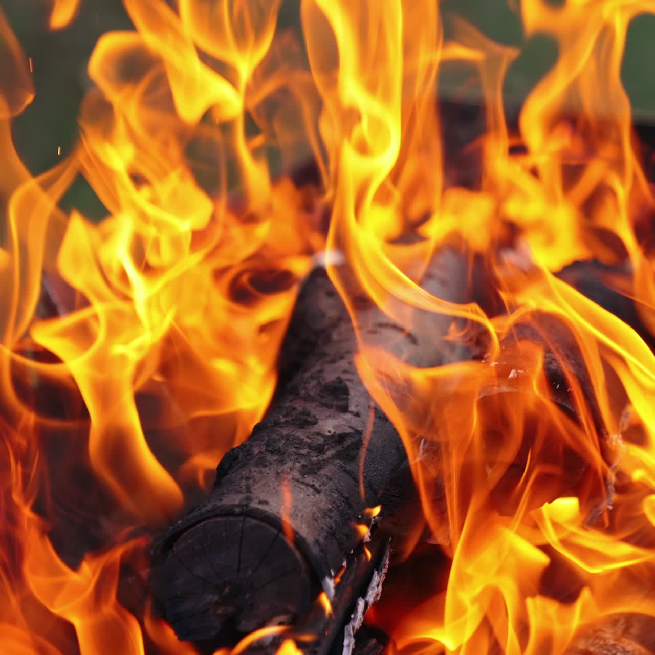 Detailed motion of vivid flame. Twisting tongues of dancing fire. Orange fire flame and slight smoke on blur background. Close-up. Slow motion