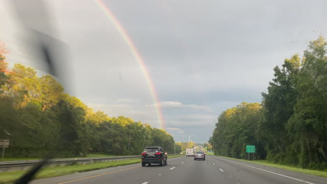 Arco-Iris-Doble-Desde-La-Autopista-Mientras-Conduce-En-Un-Viaje-Por-Carretera