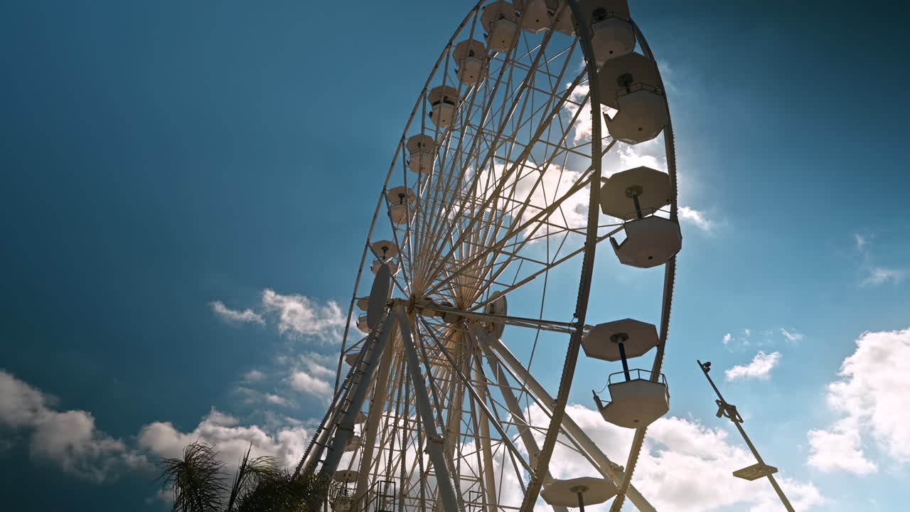 vista de la rueda gigante cerca del puerto de antibes, cielo parcialmente nublado y sol brillante, francia