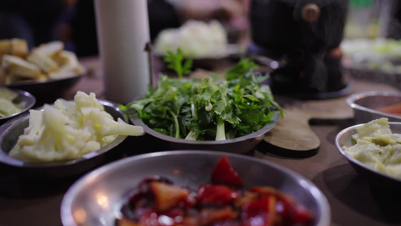 Spread of vegetables and ingredients on a table for Bagna Cauda meal preparation.