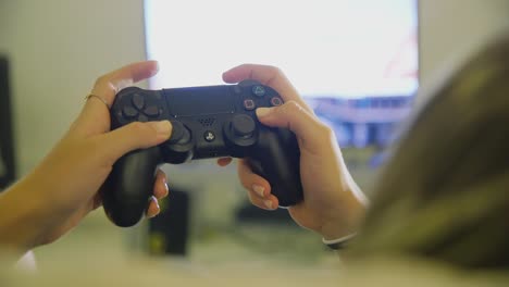 Weibliche-Hände-Mit-Schwarzem-Ps4-Dualshock-controller,-Um-Spiel-Zu-Hause-Mit-Fernseher-Im-Hintergrund-Zu-Spielen