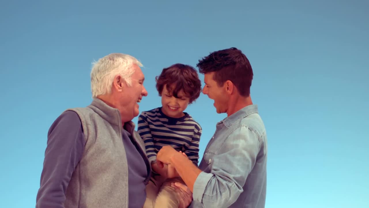 Father and grandfather tickling boy