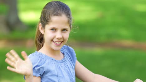 little girl smiling and waving at camera on a pink bike