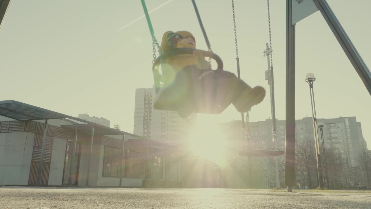 Child playing on swing in winter