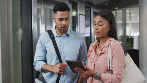 Video-of-diverse-businesswoman-and-businessman-using-tablet-and-talking