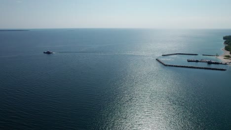 Drone-shot-of-a-ferry-leaving-port-in-door-county,-Wisconsin-on-a-sunny-day