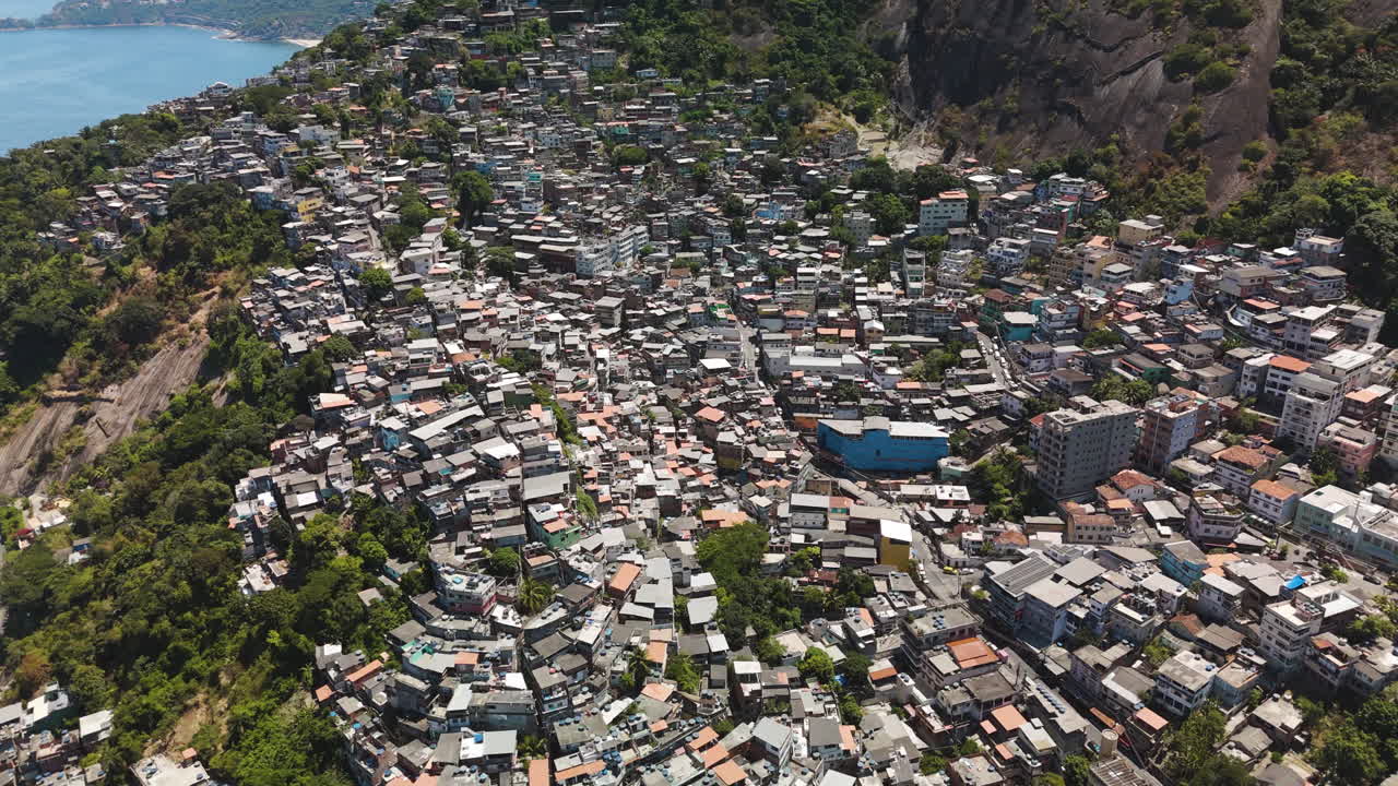 Top-down aerial shows Favela Vidigal's maze of colourful hillside homes, Rio de Janeiro