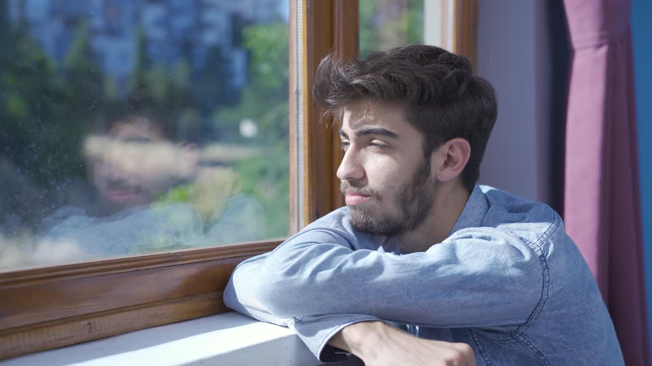 Hombre emotivo mirando por la ventana