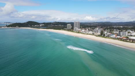 scenery of holiday resort buildings and pristine blue water at palm beach in queensland, australia