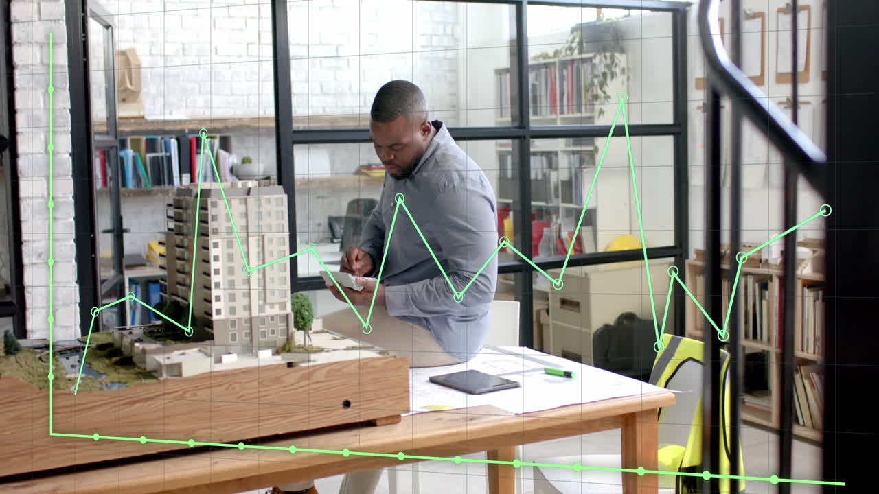 Traitement des données sur un graphique au-dessus d'un architecte afro-américain étudiant une maquette de bâtiment