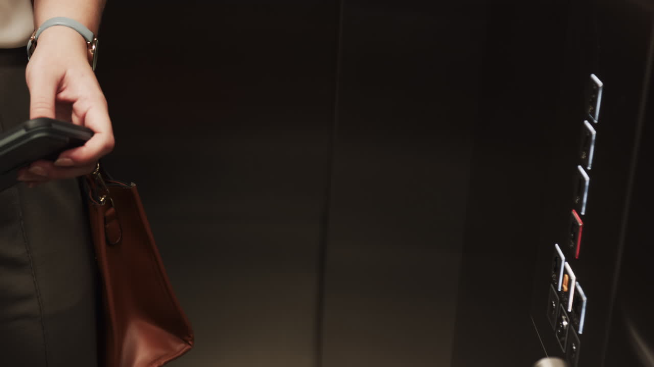 Holding briefcase, person pressing elevator buttons in office building