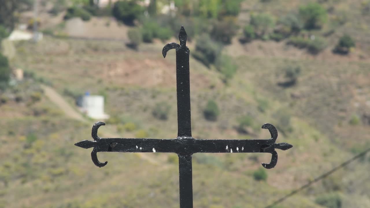 Ancient spanish iron cross in entrance of a cemetery, Sayalonga, Spain