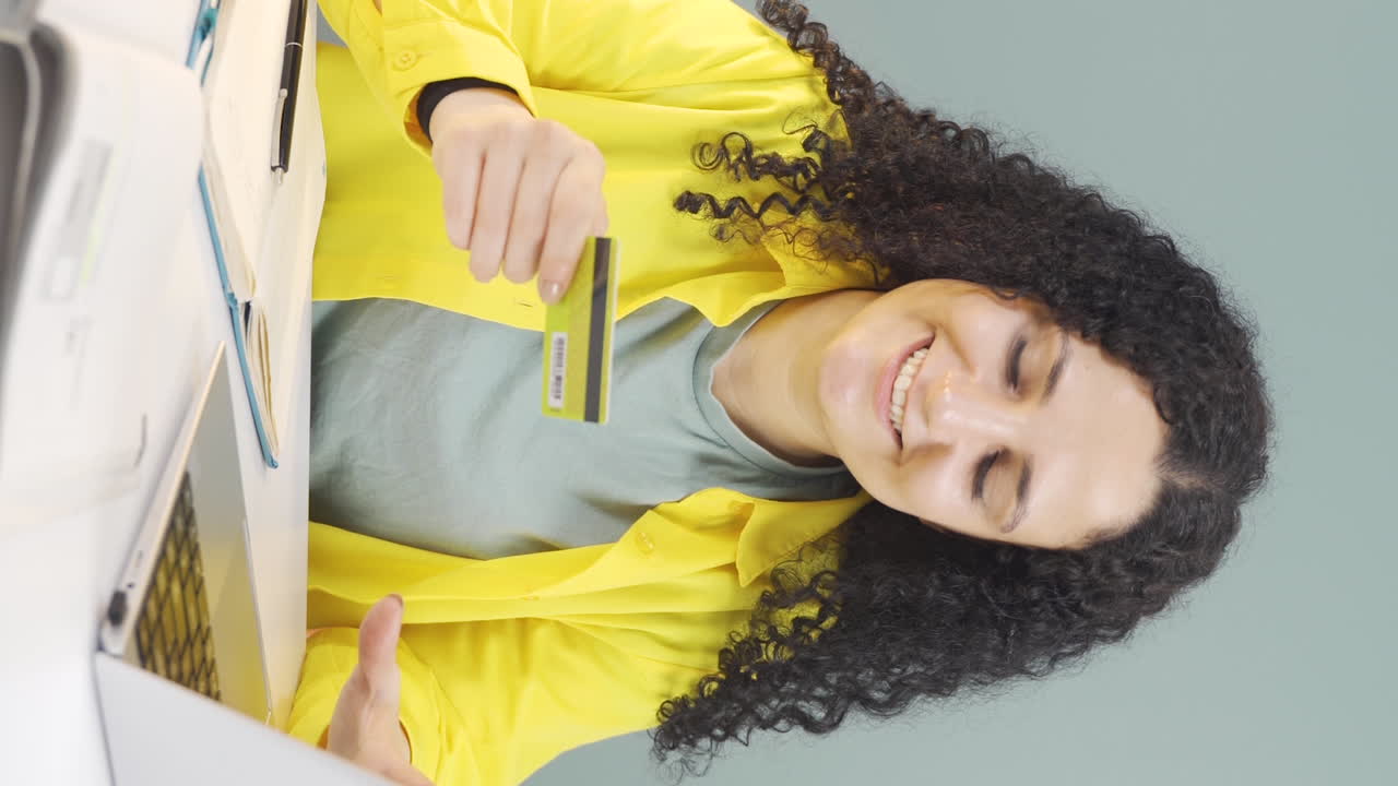 video vertical de una mujer joven comprando desde una computadora portátil.