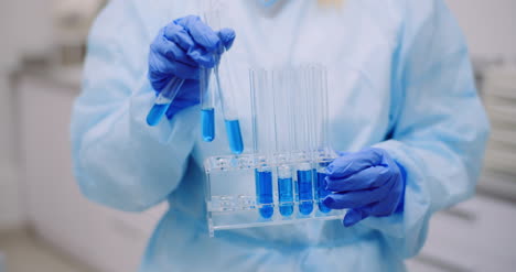 científica femenina sosteniendo tubos y matraz con líquido en las manos 13