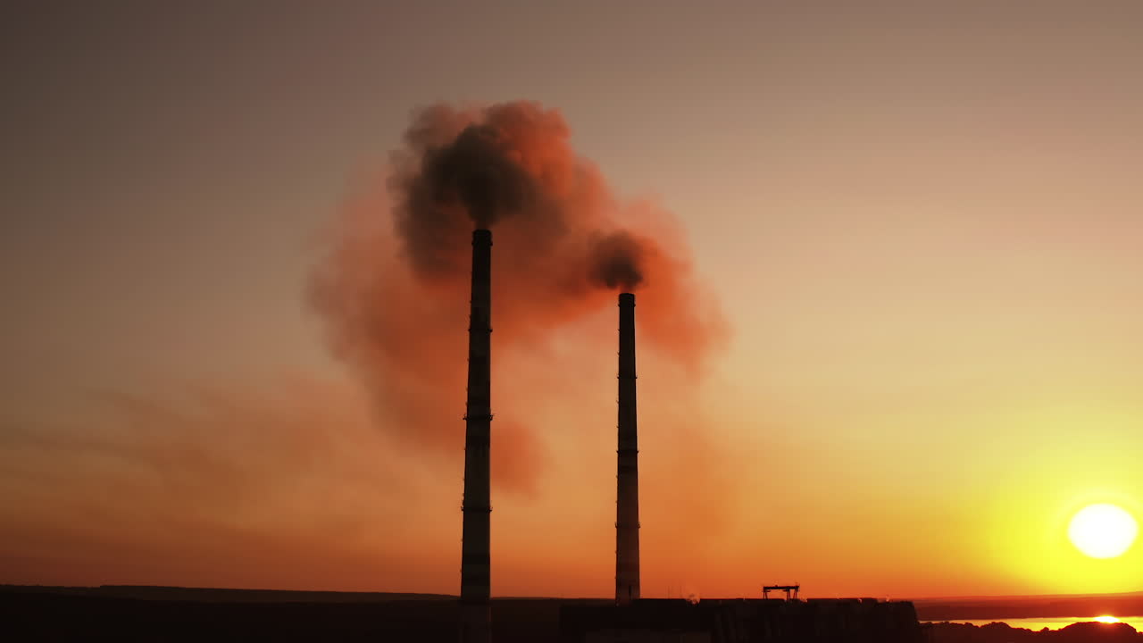 Industrial factory pollution of ecology. Aerial drone footage of factory pipes during sunset time