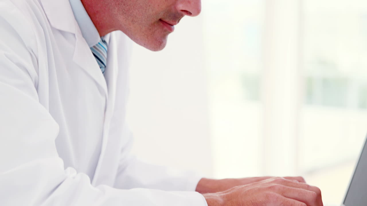 médico trabajando en su portátil