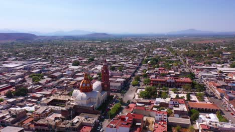 drone: dolly in shot of downtown apatzingan at noon with the cathedral