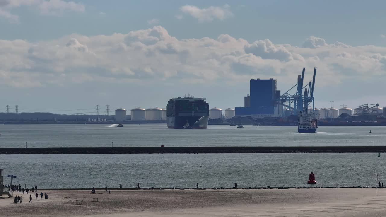 네덜란드 의 산업 항구 를 내려다보는 호크 반 홀랜드 해변 에서 산책 하는 사람 들