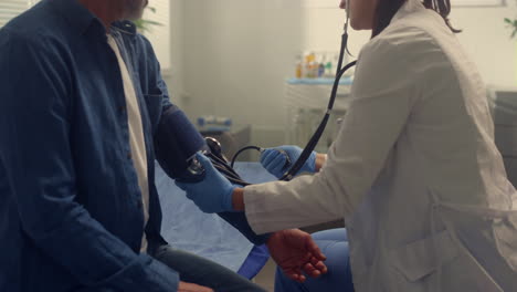 therapist checking pressure patient in clinic close up. doctor examining old man