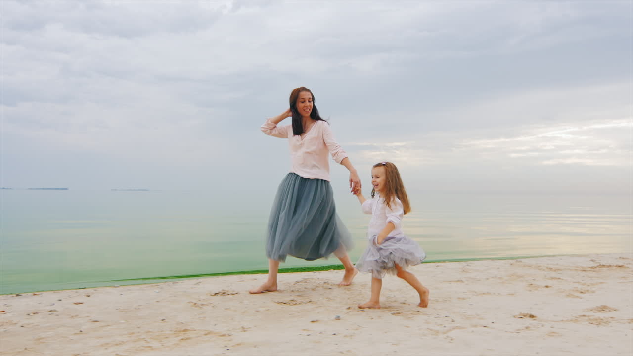 평온한 엄마와 딸이 해변에서 3년을 달리다
