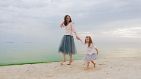 carefree mother and daughter three years running by the beach