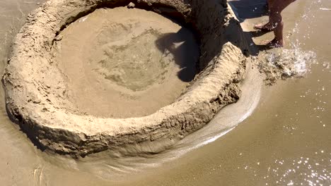 energetic girl constructs a sand wall against the ocean waves on a sunny day, embodying the spirit of summer vacation with her enthusiastic beach activity