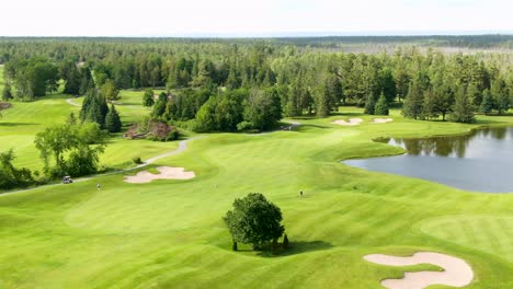 Telephoto-aerial-shot-of-golfers-walking-and-playing-on-a-golf-course-in-Oakville,-Ontario