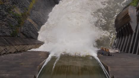 top down handheld shot of hinze dam overflow under heavy rain during la niña, gold coast hinterland, queensland, australia