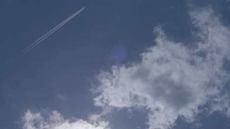 Inclinación-De-Mano-De-Una-Hermosa-Tarde-Azul-Soleada-Con-Pocas-Nubes-Y-Estelas-De-Avión