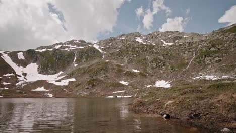 Timelapse-of-alpine-mountain-lake-with-clouds-and-waterfall